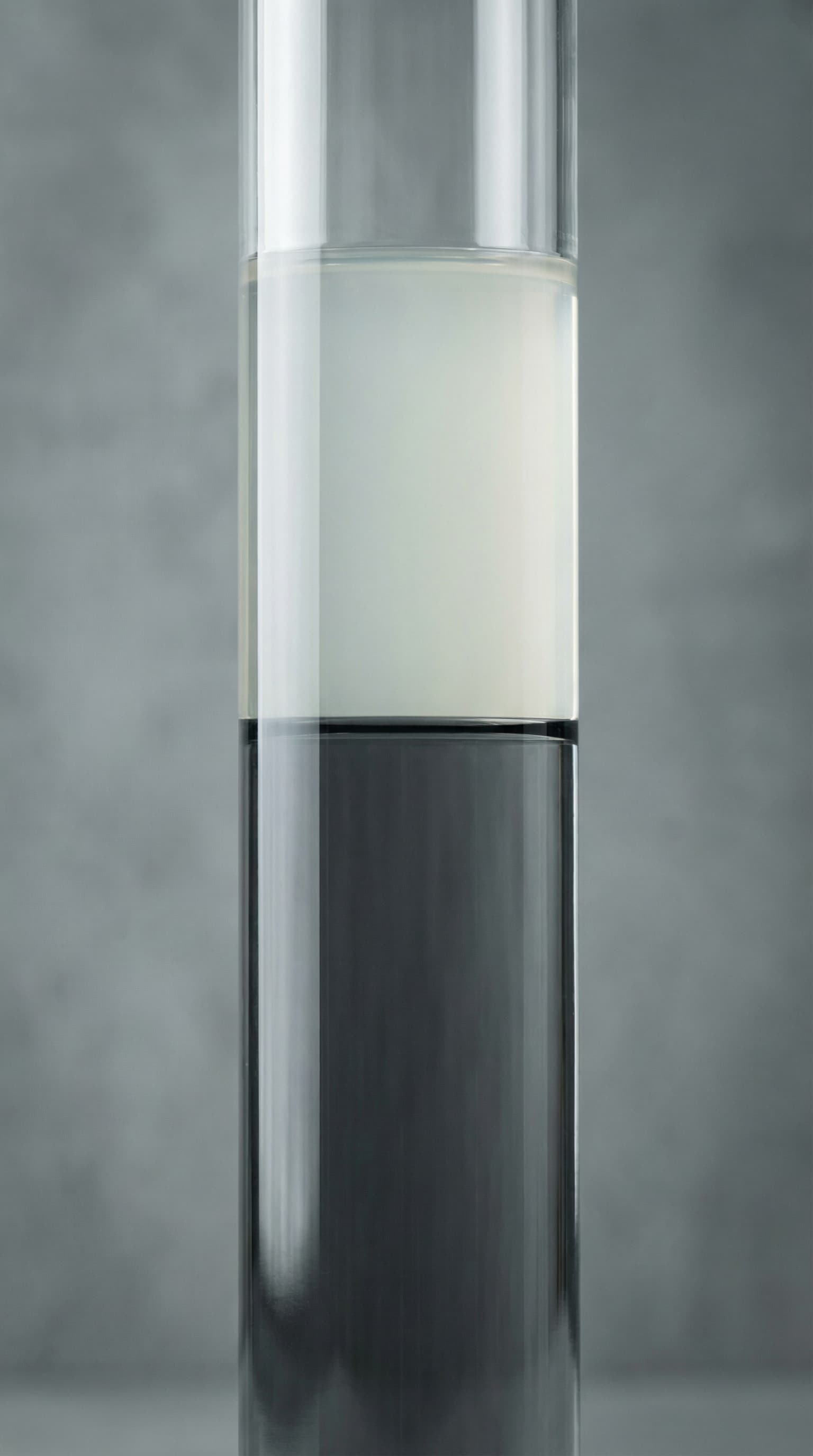 Glascylinder med svampeekstrakt, der viser tydelig faseadskillelse mellem lys og mørk fraktion som led i ekstraktions- og klaringsprocesser under kontrollerede laboratorieforhold.