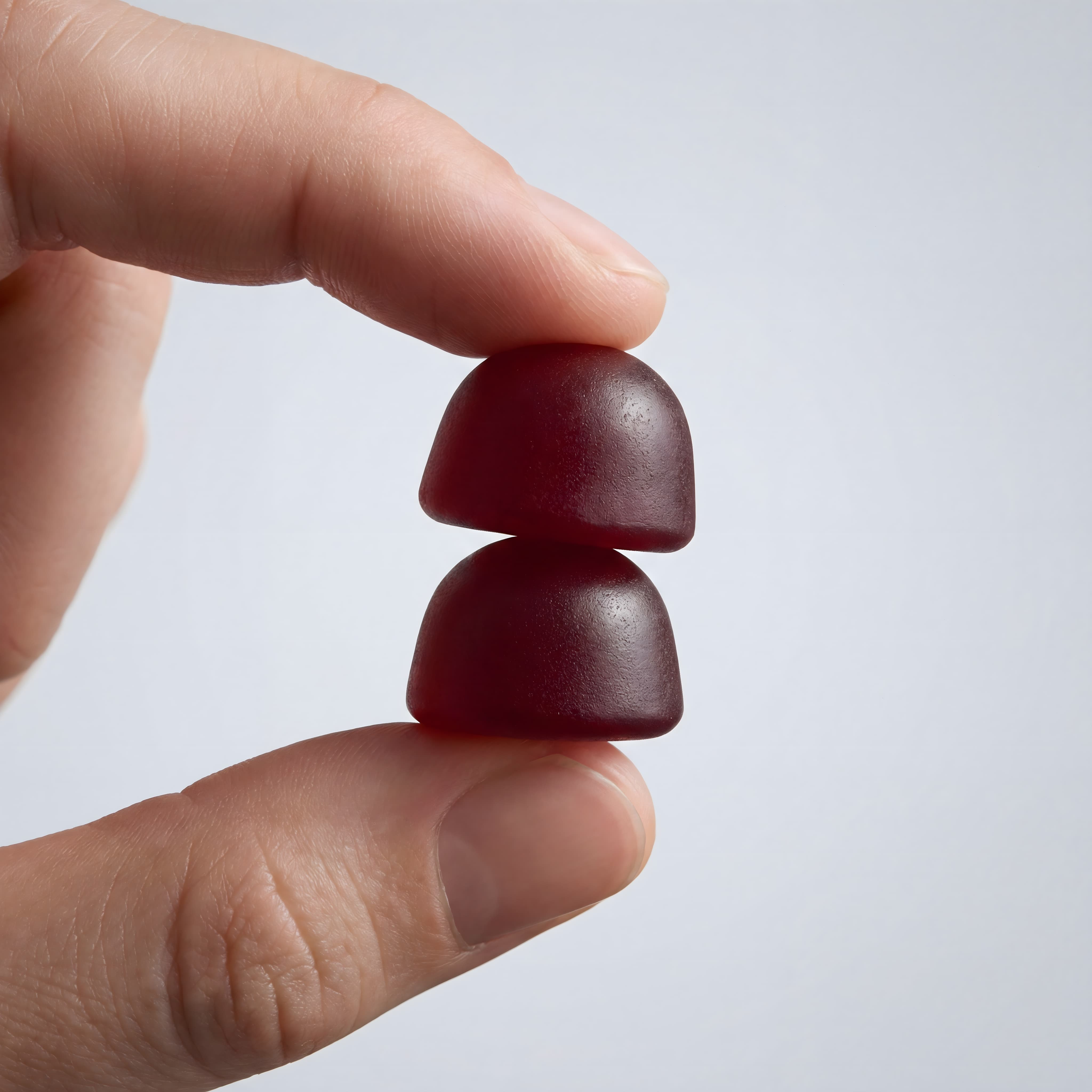 To Lion’s Mane gummies holdt mellem fingre med fokus på form og tekstur