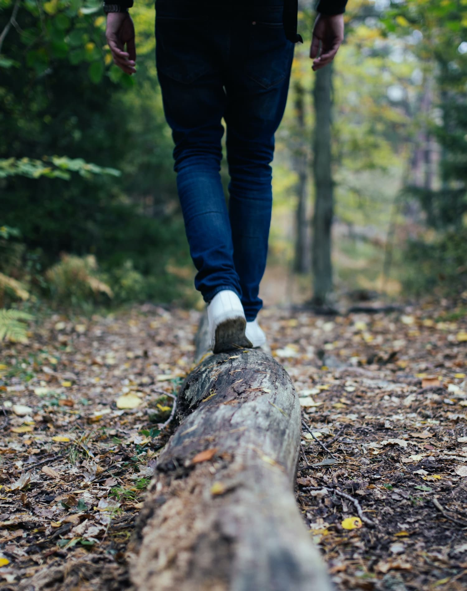 Person går i roligt tempo på skovsti – moderne symbol på balance og nærvær.